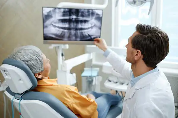 Patient in dental chair looking at xray with Dentist